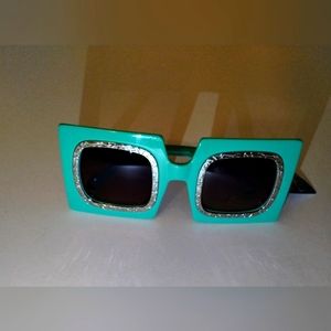 Green Square sunglasses with broken silver designs around the lenses